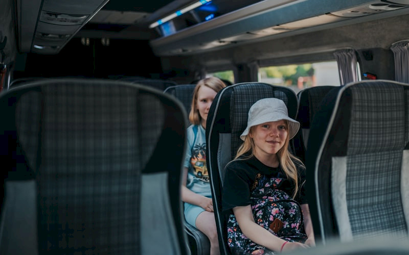 Kaksi tyttöä istuu bussissa koulukyydityksessä